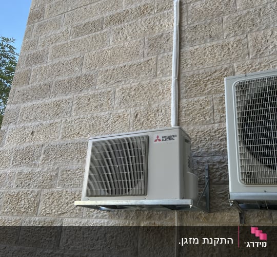 יחידת מיזוג אוויר מותקנת על קיר אבן חיצוני